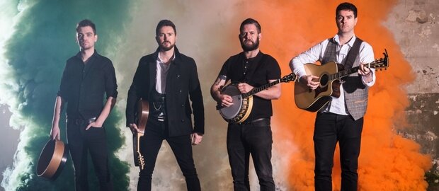 Die vier Musiker der irischen Band The Kilkennys stehen nebeneinander und halten ihre Instrumente in den Händen