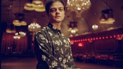 Fotografie Jamie Cullum im Hintergrund mit Kronleuchtern.