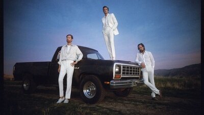 Fotografie The Killers um einen Truck herum stehend.