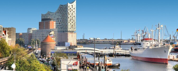 Im Hafen der Musikstadt Hamburg treiben viele Schiffe auf der Elbe und die Elbphilharmonie sticht als touristisches Highlight und Hamburger Wahrzeichen heraus.