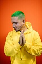 J Balvin Fotografie mit gelbem Hoodie.