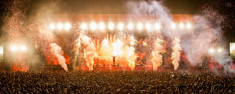 Der Festivalplaner präsentiert ein Bild der Menschenmasse und der Bühnenshow beim Deichbrand Festival 2015.