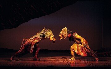 Der König der Löwen Musical in Hamburg Bühnenbild. Zwei Löwen kämpfen.