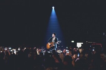 Johannes Oerding performt live mit seiner Gitarre auf der Bühne.