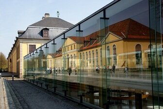 Das Bild zeigt das Galeriegebäude von Herrenhausen Hannover im Fensterglas gespiegelt