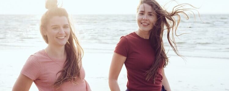 Josepha und Cosima Carl, bekannt als das JOCO Duo, posieren am Strand.