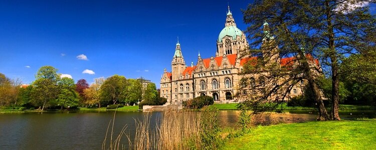 Das neue Rathaus mit dem Hannoverschen Maschsee im Vordergrund bei frühlingshaftem Wetter.