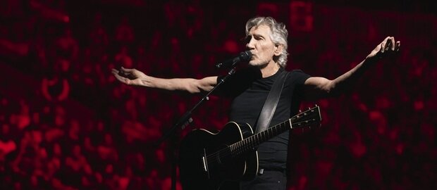 Roger Waters auf der Bühne mit einer akustischen Gitarre um den Hals
