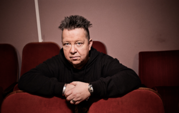 Sebastian Krumbiegel sitzt auf einem Sessel und sieht in die Kamera