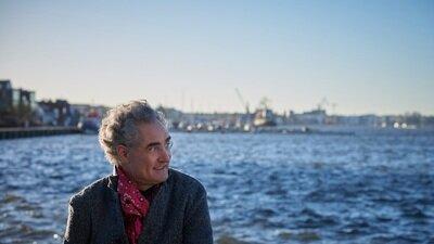 Matthias  Kirschnereit sitzt am Hafen und sieht nach links